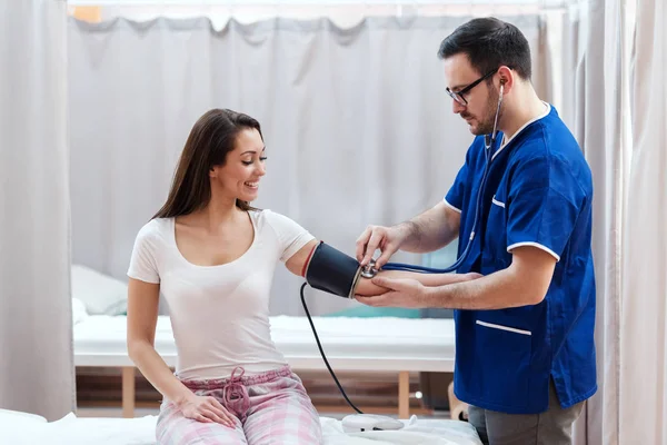 Medico Piedi Misurare Pressione Sanguigna Mentre Suo Paziente Sorride Seduto — Foto Stock