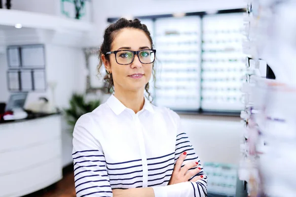 Portrét Atraktivní Kavkazských Brunetka Brýlemi Stojí Rukama Zkříženýma Obchodě Oftalmolog — Stock fotografie