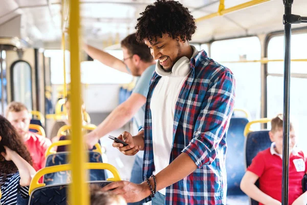 Genç Gülümseyen Afro Amerikan Adam Akıllı Telefon Kullanıyor Şehir Otobüsünde — Stok fotoğraf