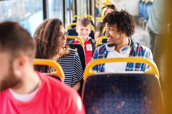 Unga Leende Mångkulturella Par Talar Medan Sitter Stadsbussen — Stockfoto