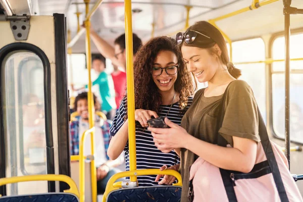 Dos Amigos Riendo Viendo Teléfono Mientras Esperan Salida Del Autobús — Foto de Stock