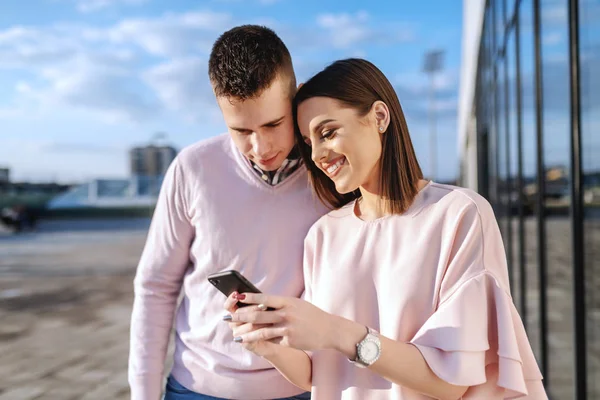 Joven Pareja Caucásica Moda Pie Balcón Mirando Teléfono Inteligente — Foto de Stock