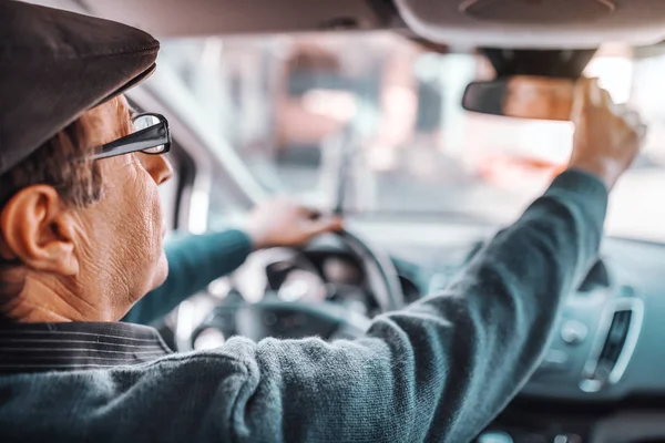 Starszy Mężczyzna Kapeluszem Okularami Regulując Tylne Lusterko Siedząc Samochodzie Drugiej — Zdjęcie stockowe