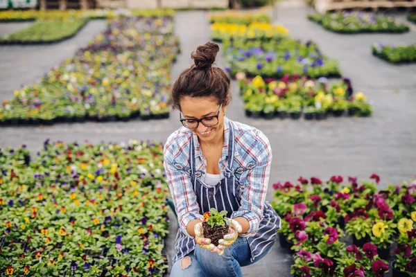 Schattige Lachende Bloemist Crouching Buitenshuis Omgeven Door Bloemen Holding Pot — Stockfoto