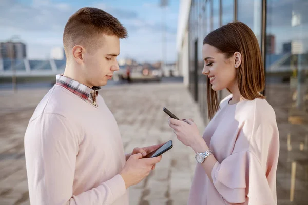 Bonito Casal Branco Sorridente Vestido Elegante Livre Usando Telefones Inteligentes — Fotografia de Stock