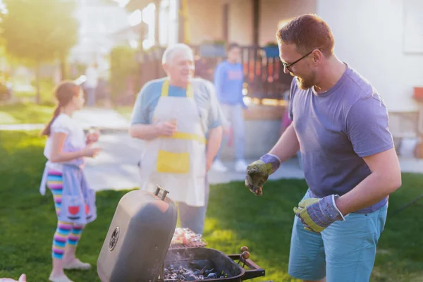 快乐的中年男人在后院为家人做烧烤 在阳光明媚的夏日一起度过一段时光 — 图库照片