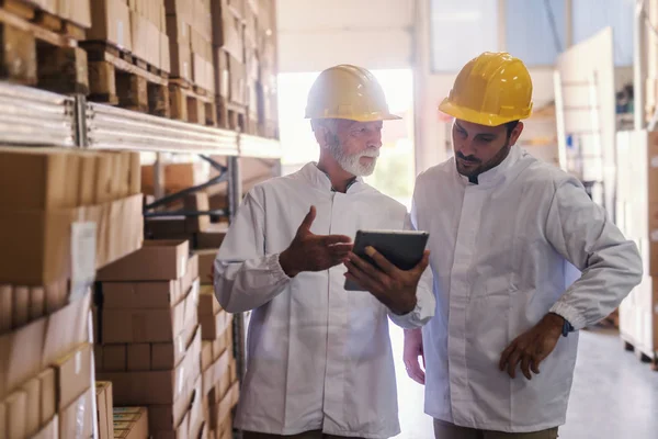 Dois Colegas Trabalho Uniforme Branco Com Capacetes Amarelos Cabeça Olhando — Fotografia de Stock