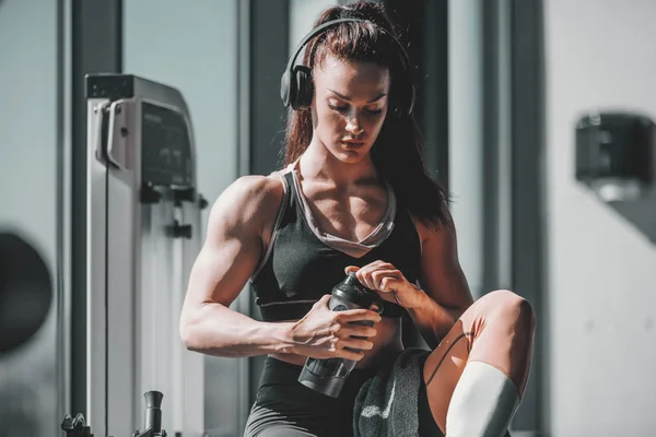 Joven Caucásica Fuerte Musculoso Mujer Culturista Sentado Gimnasio Con Auriculares —  Fotos de Stock