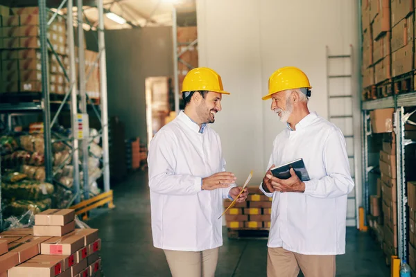 Dois Trabalhadores Uniformes Brancos Capacetes Protetores Cabeça Falando Sobre Trabalho — Fotografia de Stock