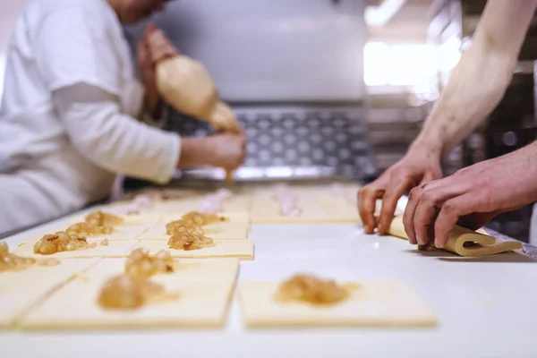 高加索勤劳的面包师用果酱做面包卷 烘焙屋内部 — 图库照片