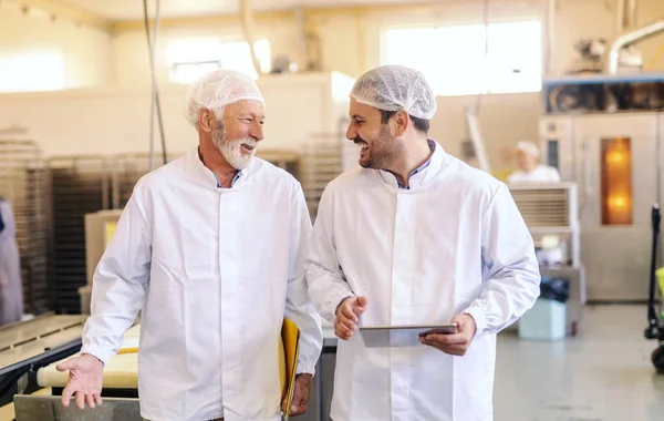 Jovem Supervisor Conversando Com Empregado Sorrindo Segurando Tablet Enquanto Caminha — Fotografia de Stock