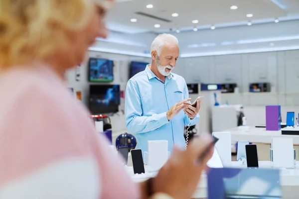 Vousatý Muž Stojící Obchodě Zkouší Inteligentní Telefon — Stock fotografie