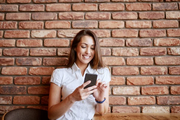 Krásná Usměvavá Bruneta Která Sedí Kavárně Používá Chytrý Telefon Pozadí — Stock fotografie