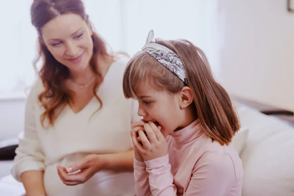 Мила Дівчинка Сидить Вітальні Їсть Печиво Задньому Плані Вагітна Мама — стокове фото