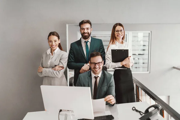 Successful corporate handsome people dressed formally posing in office.