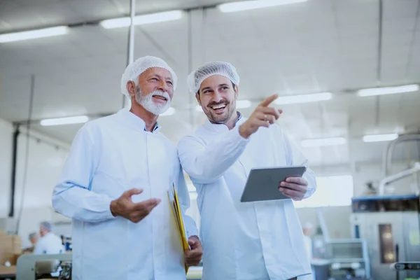 Två Leende Kaukasiska Handledare Vita Sterila Uniformer Stående Livsmedels Fabriken — Stockfoto