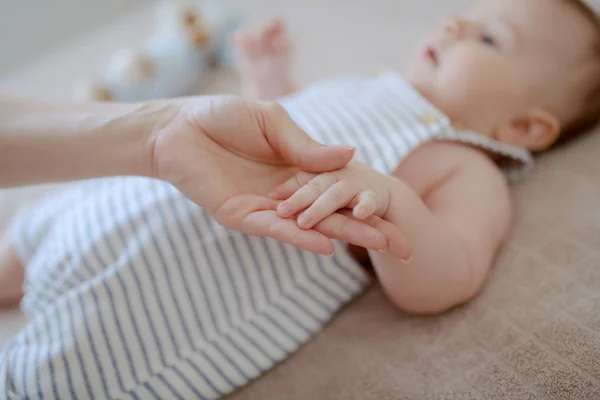 Feche Mão Minúscula Mãe Segurando Filho Bebé Deitado Cama Foco — Fotografia de Stock