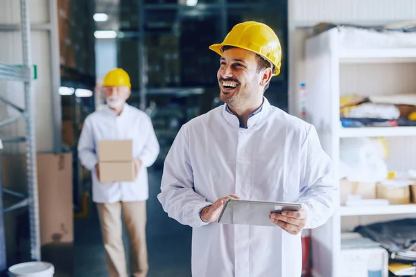 Jovem Trabalhador Armazém Branco Sorridente Uniforme Branco Capacete Amarelo Cabeça — Fotografia de Stock