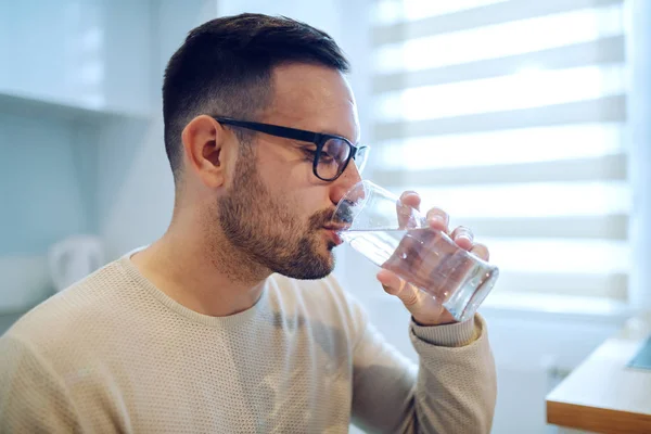 Zijaanzicht Van Mooie Blanke Man Zittend Aan Eettafel Drinkwater — Stockfoto