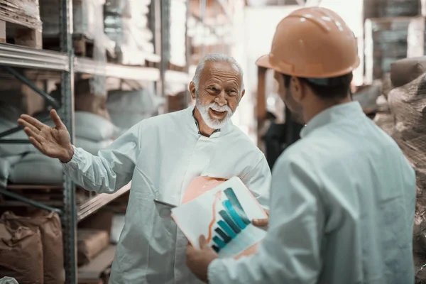 Two Hardworking Supervisors Analyzing Sale While Standing Warehouse Younger One — ストック写真