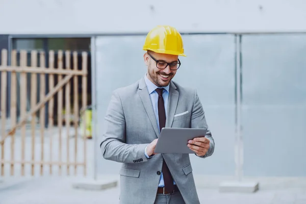 Feliz Arquitecto Caucásico Traje Con Casco Cabeza Usando Tableta Mientras —  Fotos de Stock