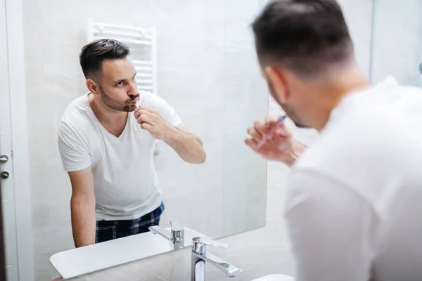 Yakışıklı Beyaz Adam Pijamalarıyla Banyoda Duruyor Sabahları Dişlerini Yıkıyor Aynada — Stok fotoğraf