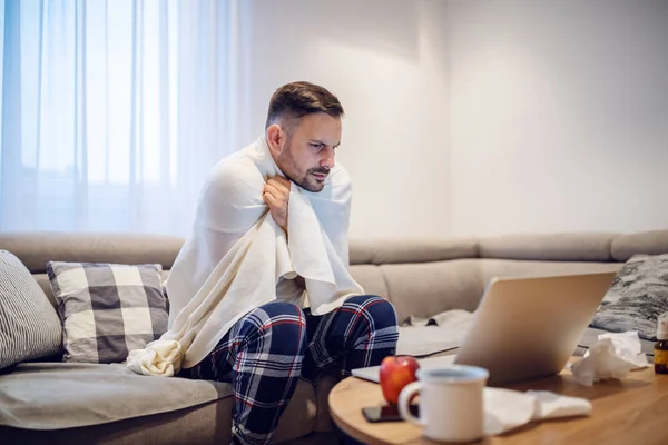 Oddaný Běloch Pyžamu Přikrytý Dekou Dívající Laptop Zatímco Sedí Obývacím — Stock fotografie