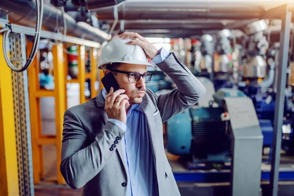 Kafkasyalı Işadamı Elektrik Santralinde Dikilirken Telefonla Konuşup Kafasını Tutuyor — Stok fotoğraf