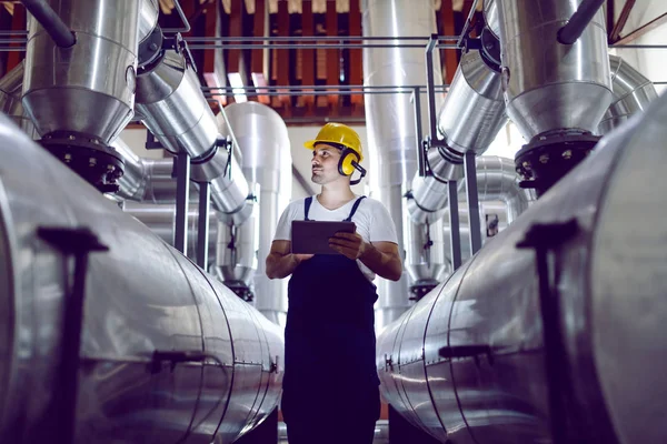 Fokussierter Fabrikarbeiter Overalls Mit Schutzhelm Auf Dem Kopf Und Antiphonen — Stockfoto