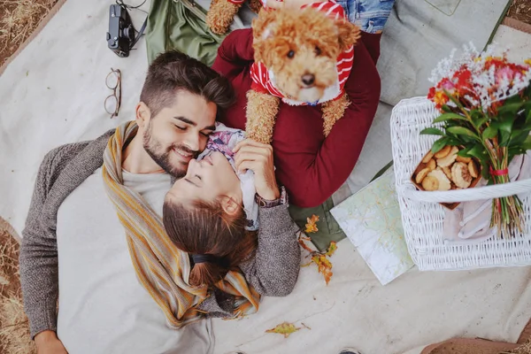 愛の多文化カップルのトップビューは 毛布の上に横たわって 抱きしめ 犬を保持しています 秋のコンセプトでピクニック — ストック写真
