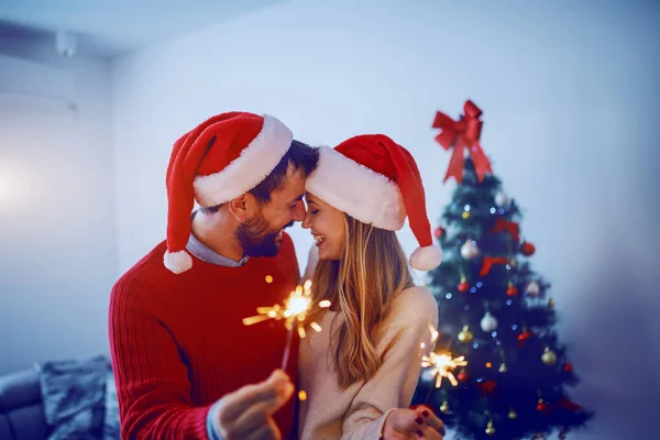 Kafalarında Noel Baba Şapkası Olan Mutlu Beyaz Bir Çift Oturma — Stok fotoğraf