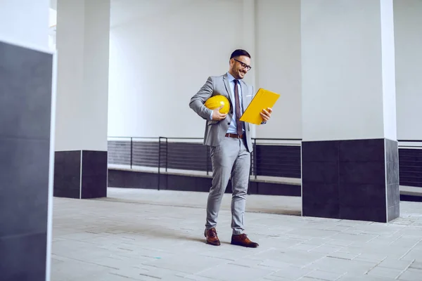 Smiling Caucasian Dedicated Contractor Suit Looking Folder Documents Holding Helmet — Stock Photo, Image