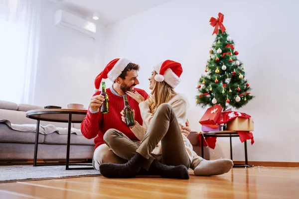 Bedårande Snygg Vit Par Med Santa Hattar Huvuden Sitter Golvet — Stockfoto
