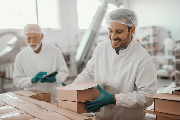 Uśmiechnięty Ciężko Pracujący Biały Pracownik Układający Pudełka Podczas Gdy Jego — Zdjęcie stockowe