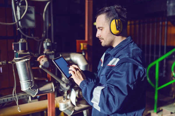Fokussierte Gut Aussehende Fabrikarbeiter Arbeitskleidung Und Mit Antiphonen Tablet Werksinnenraum — Stockfoto