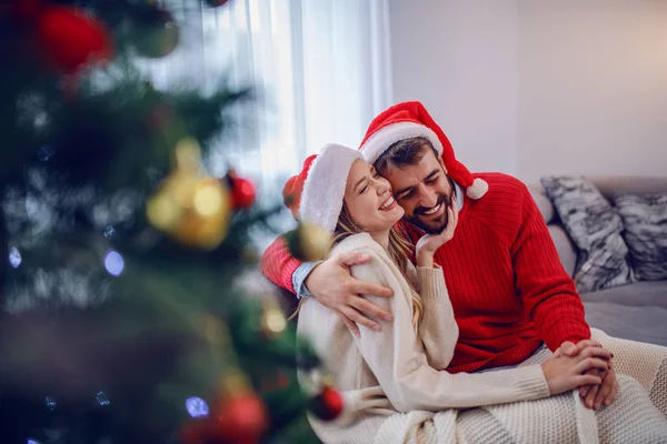 Okouzlující Kavkazský Pár Svetrech Santa Klobouk Hlavách Sedí Pohovce Obývacím — Stock fotografie