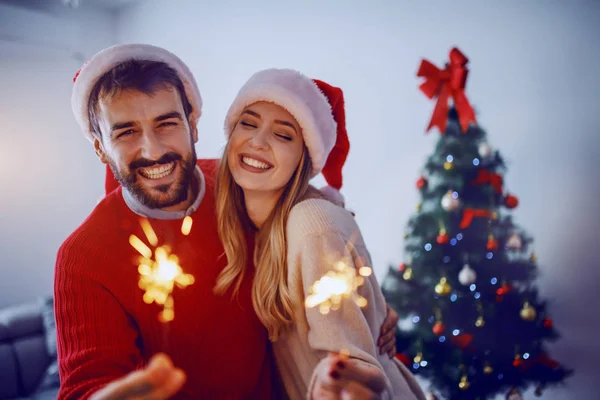 Glad Kaukasiska Par Med Santa Hattar Huvuden Som Håller Sprinklers — Stockfoto