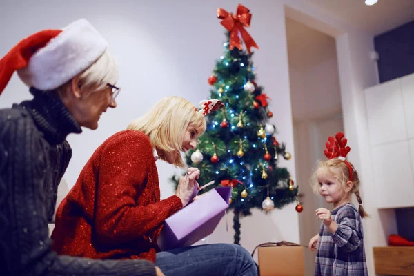 Fröhliche Blonde Kaukasische Mutter Öffnet Weihnachtsgeschenk Während Sie Auf Dem — Stockfoto