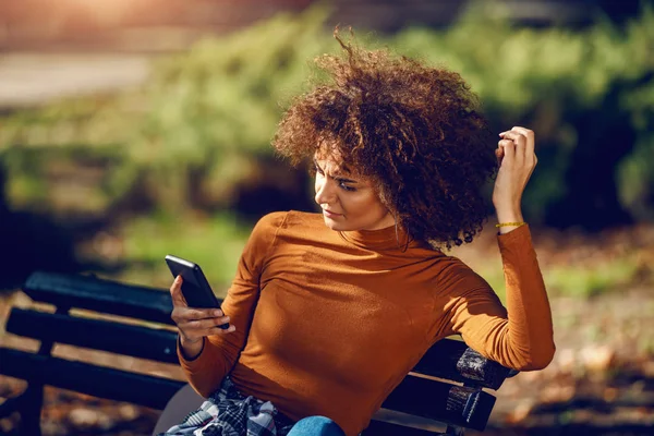 Ernstige Gemengde Ras Jonge Vrouw Met Krullend Haar Coltrui Zitten — Stockfoto