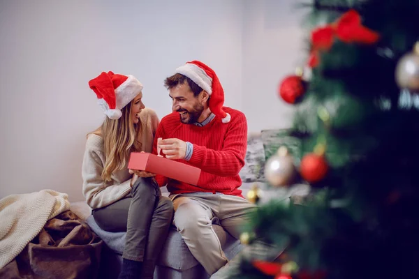 Homem Caucasiano Bonito Feliz Abrindo Presente Natal Enquanto Sentado Lado — Fotografia de Stock