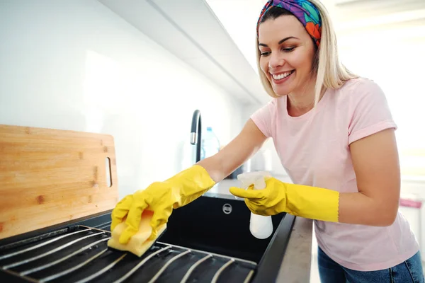 手洗浄キッチンシンク上のゴム手袋と価値のある笑顔の白人ブロンドの女性 キッチンインテリア — ストック写真