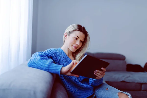 Beautiful Caucasian Smiling Blonde Blue Sweater Jeans Sitting Sofa Living — Stock Photo, Image