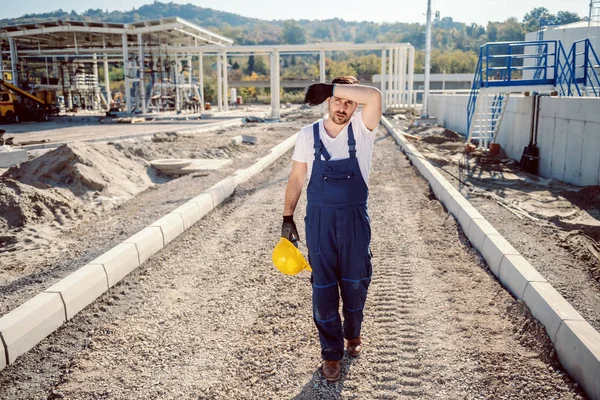 Trött Kaukasiska Stilig Arbetare Övergripande Promenader Utomhus Hålla Hjälm Och — Stockfoto