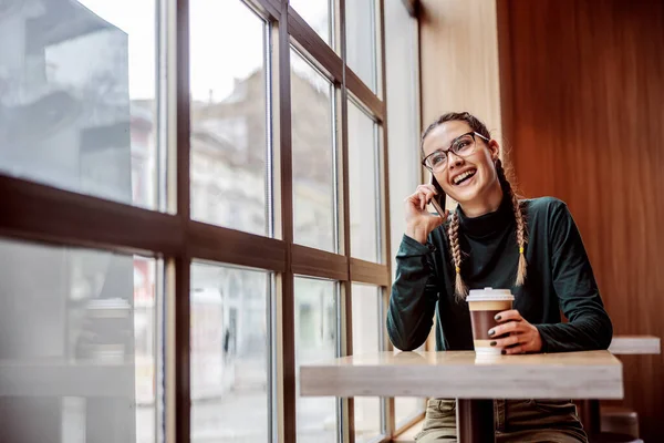 Mosolygó Pozitív Ebédlőben Kezében Eldobható Csésze Kávé Telefonbeszélgetés Barátjával — Stock Fotó