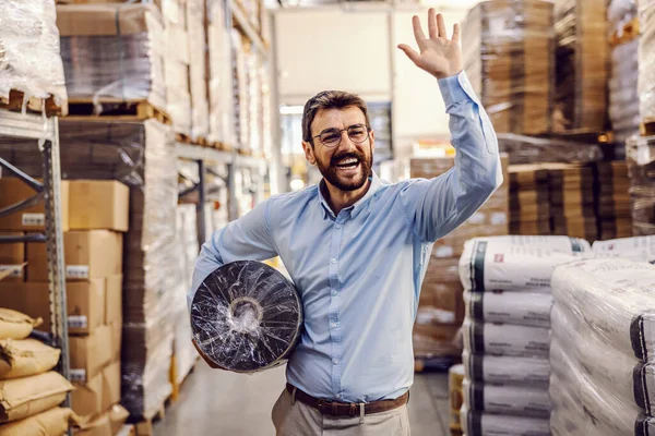 Jovem Sorrindo Empregado Barbudo Segurando Rolo Realocando Enquanto Acena Para — Fotografia de Stock