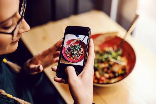 Mujer Tomando Fotos Ensalada Mientras Está Sentada Restaurante Cerca Ventana — Foto de Stock