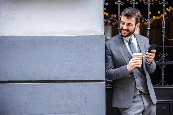 Jonge Aantrekkelijke Bebaarde Zakenman Leunend Muur Met Een Kopje Koffie — Stockfoto