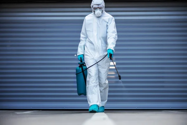 カメラの方へ歩いている間に滅菌保護スーツとマスク消毒表面の男の完全な長さ — ストック写真