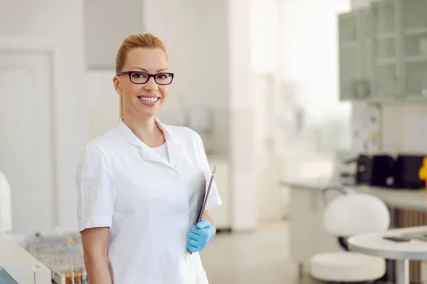 Fiatal Mosolygós Szőke Női Laboratóriumi Asszisztens Áll Laboratóriumban Tabletta Hónalj — Stock Fotó