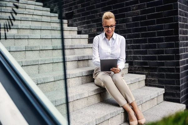 Atraktivní Blond Úsměvem Módní Obchodnice Sedí Schodech Venku Pomocí Tabletu — Stock fotografie